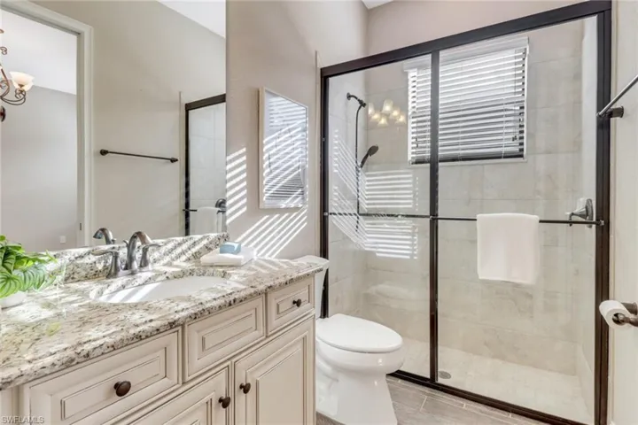 Full bathroom featuring a stall shower, vanity, and toilet