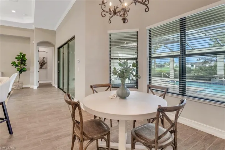 Dining space featuring arched walkways, wood finish floors, crown molding, and baseboards