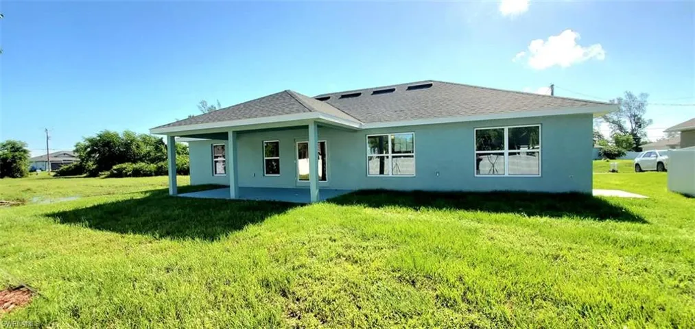Back of house with a yard and a patio