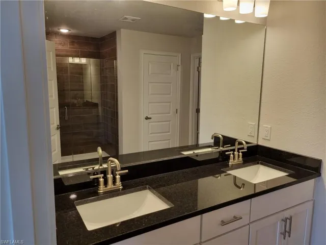 Bathroom featuring a shower with door and vanity