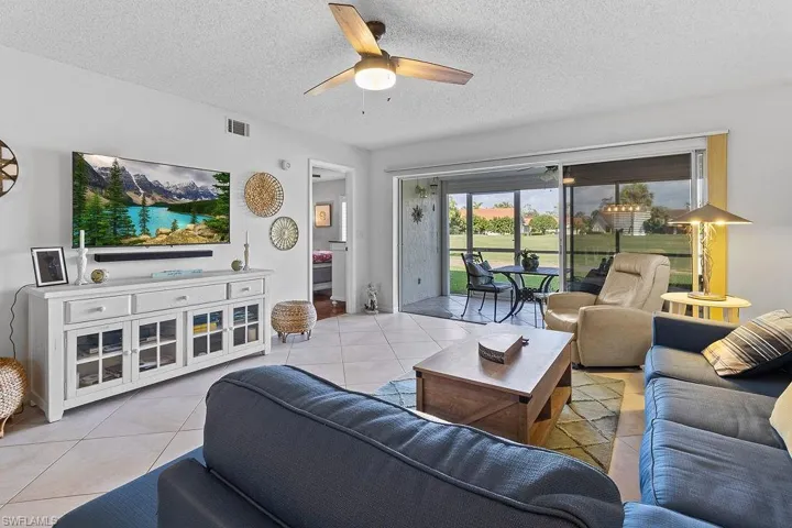Living room well appointed with upscale furniture and peaceful view of the 18th hole and tee box.