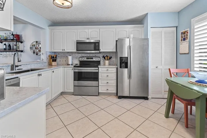 Updates kitchen has quartz countertops and stainless steel appliances