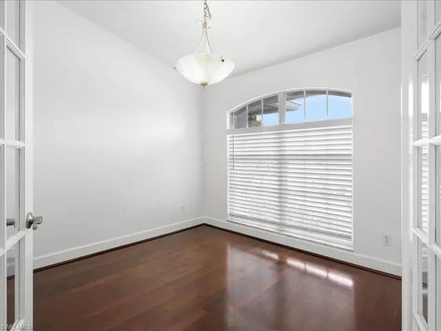 Bright room featuring dark wood-finish flooring and white walls