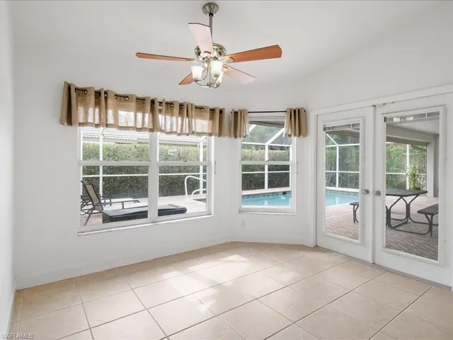 White interior room featuring large tile flooring and a ceiling fan with light fixture