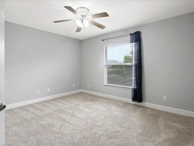 Neutral-toned room featuring light gray walls and plush carpeting