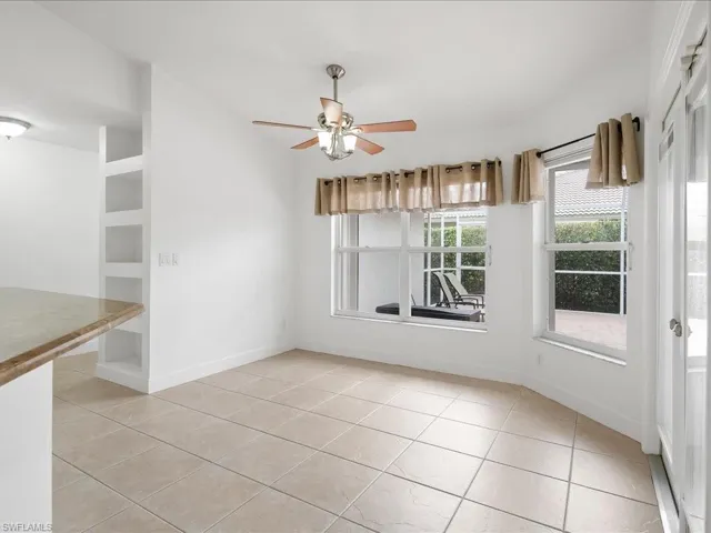 Bright interior space featuring light-toned tile flooring and multiple windows