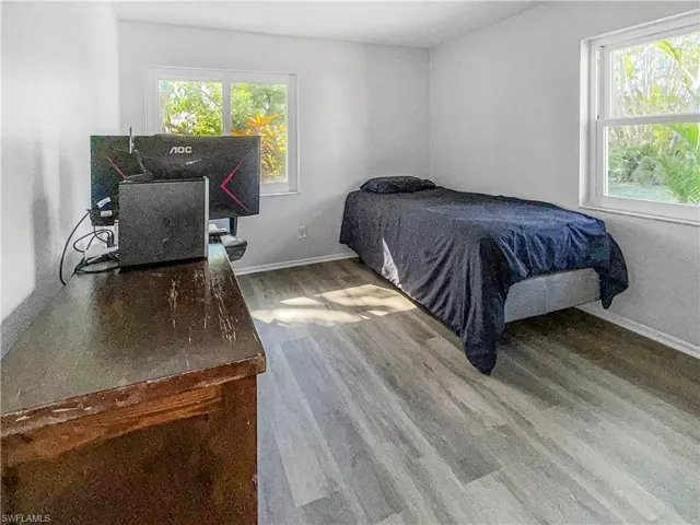 Bedroom with wood finished floors and baseboards