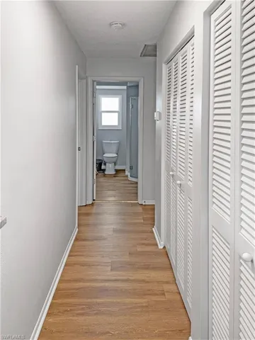 Hallway featuring light wood finished floors and a textured ceiling