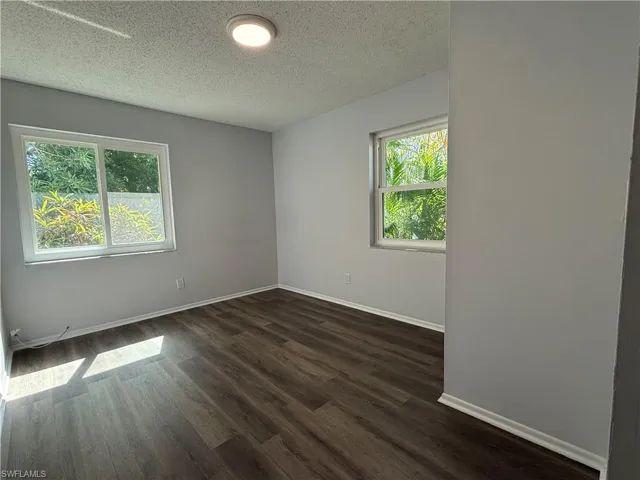 Interior space featuring wood-finish flooring, light gray wall paint, and white trim
