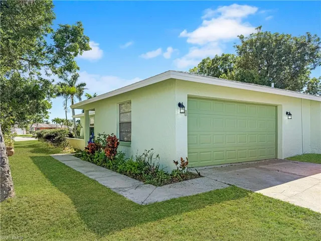 View of home's exterior with a lawn, driveway, stucco siding, and a garage