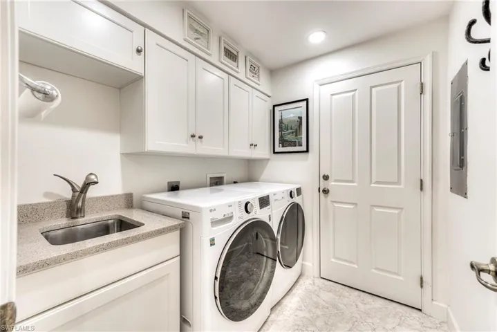 Washroom with cabinet space, washing machine and clothes dryer, and electric panel