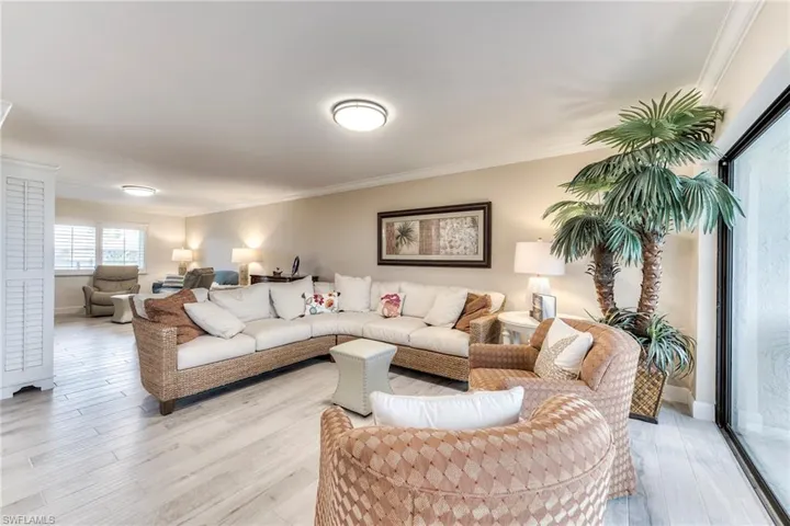 Living room with crown molding and light wood-style floors