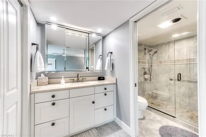 Bathroom featuring vanity, a stall shower, light tile patterned floors, a ceiling fan, and recessed lighting