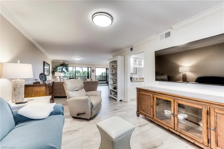 Living area with light wood-style flooring and crown molding
