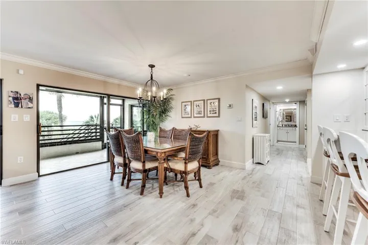 Dining room featuring crown molding, light wood finished floors, a chandelier, and recessed lighting