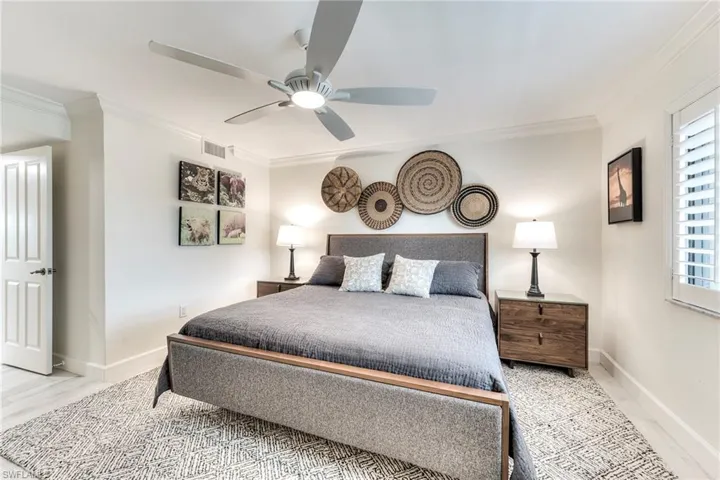 Bedroom with crown molding, a ceiling fan, and light wood finished floors