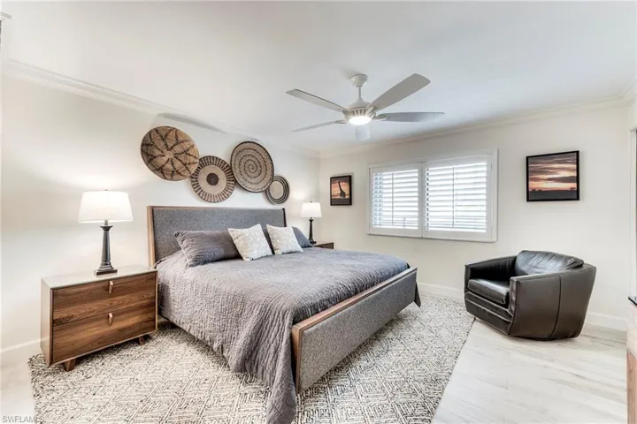 Bedroom featuring ornamental molding, a ceiling fan, and light wood finished floors
