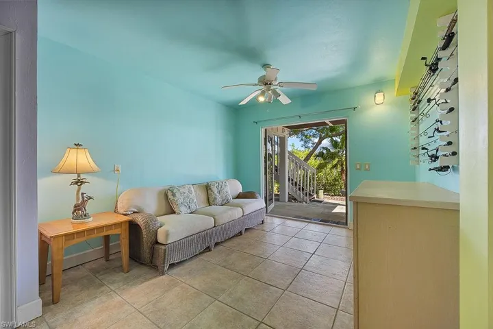 Living room with ceiling fan and light tile patterned flooring