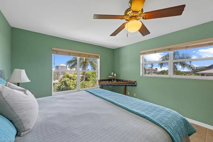 Tiled bedroom featuring ceiling fan