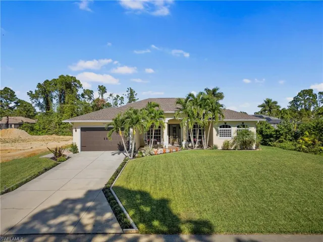 View of front of property with a front lawn, covered porch, and a garage