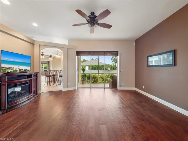 Unfurnished living room with ceiling fan and dark wood-type flooring