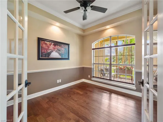 Spare room featuring hardwood / wood-style floors, crown molding, and french doors