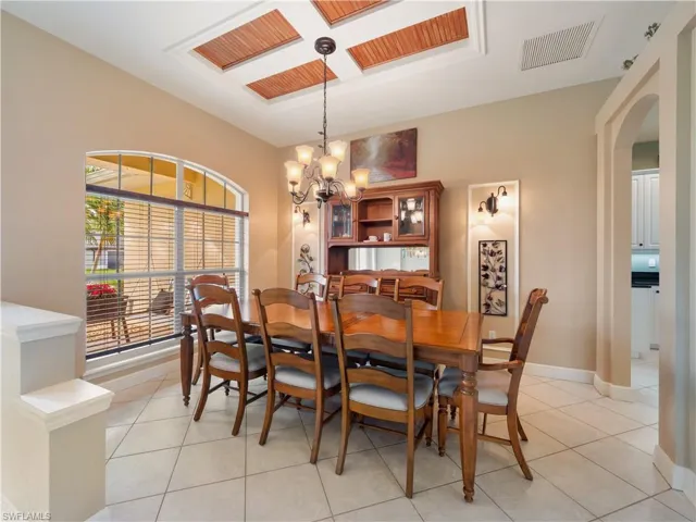 Dining space with light tile patterned floors and a chandelier