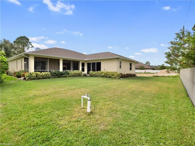 Back of house with a lawn