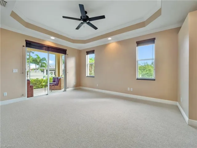Unfurnished room with a tray ceiling, ornamental molding, and light colored carpet