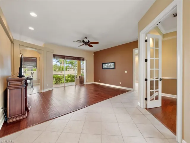 Unfurnished living room featuring ceiling fan, light hardwood / wood-style floors, crown molding, and french doors