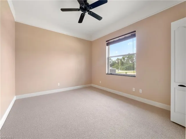Unfurnished room with ceiling fan, crown molding, and light carpet
