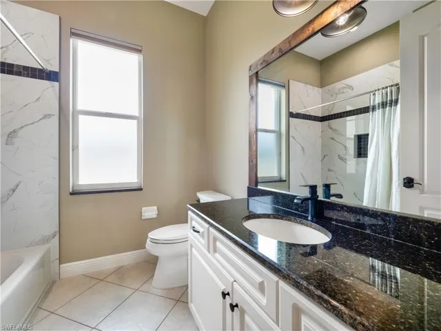 Full bathroom featuring tile patterned flooring, vanity, toilet, and plenty of natural light