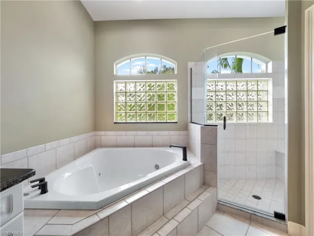 Bathroom with tile patterned floors, vanity, and independent shower and bath