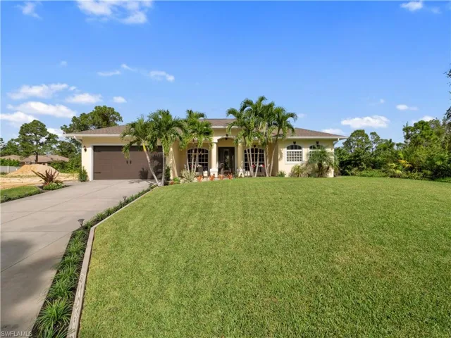View of front of home with a front yard and a garage