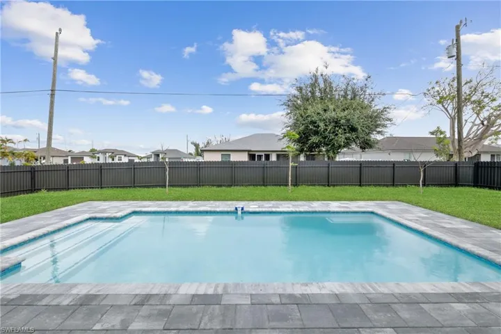 View of pool with a lawn