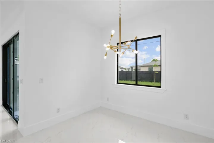 Unfurnished dining area with tile patterned flooring and a notable chandelier