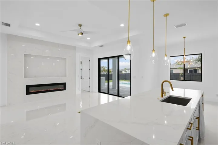 Kitchen with sink, a raised ceiling, and a healthy amount of sunlight