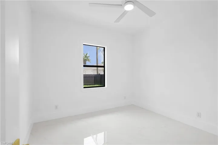 Spare room featuring ceiling fan and plenty of natural light