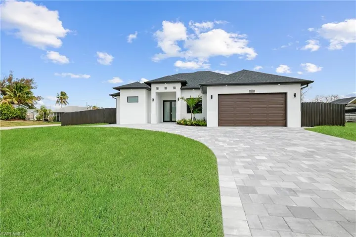 View of front of home with a garage and a front lawn