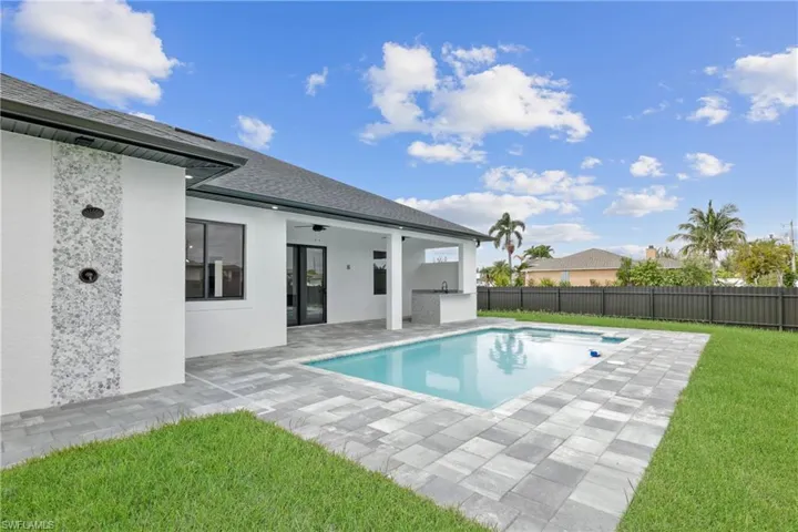 View of pool with ceiling fan, a yard, and a patio