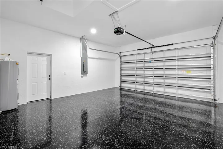 Garage featuring a garage door opener and water heater