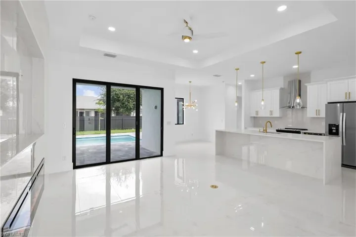 Kitchen featuring white cabinets, stainless steel fridge, and a tray ceiling