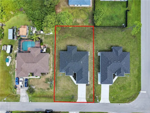 Expansive lot with a newly constructed residence featuring a dark shingle roof and a concrete driveway