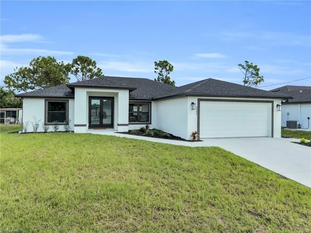 Modern stucco exterior with a dark shingle roof, double front entry doors, and a two-car garage