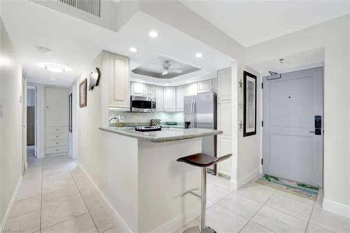 Kitchen featuring light stone counters, a peninsula, light tile patterned floors, recessed lighting, and stainless steel appliances