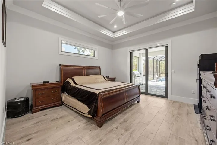 Master Bedroom with picture window, tray ceiling, crown molding, and sliders to Screened Lanai!
