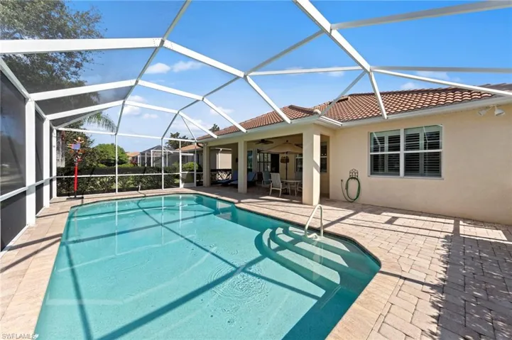 Outdoor pool with a patio area, a sunroom, glass enclosure, and ceiling fan