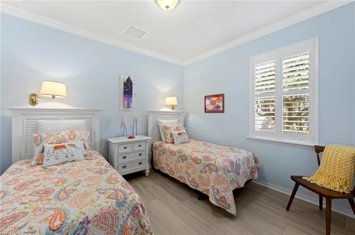 Bedroom with ornamental molding and light wood finished floors