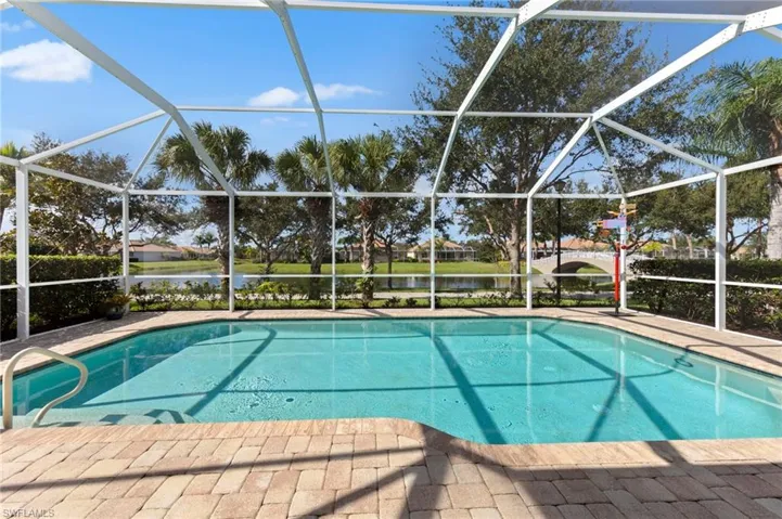 Outdoor pool with a water view, a sunroom, and glass enclosure