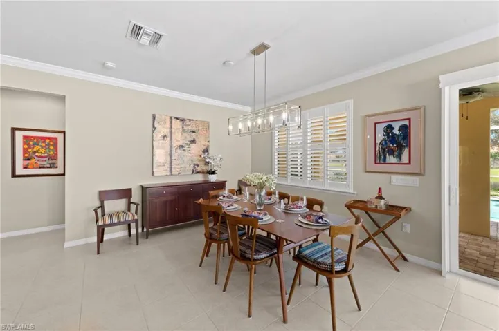 Dining room with crown molding, plenty of natural light, and light tile patterned floors